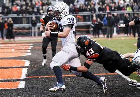 Cary-Grove's Holden Boone runs with the ball behind the block of his teammate, Andrew Prio, during a IHSA Class 6A semifinal playoff football game against Lake Zurich on Saturday, Nov. 18, 2023 ...